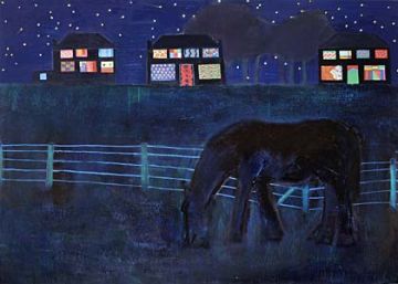 A horse grazing in a field with brightly lit houses in the background against the night sky..