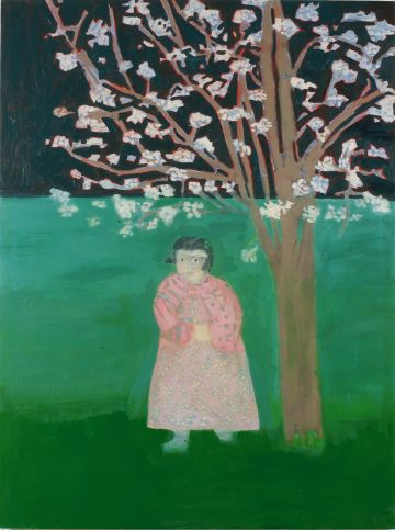 A girl in a pink dress standing beneath a blossoming tree.