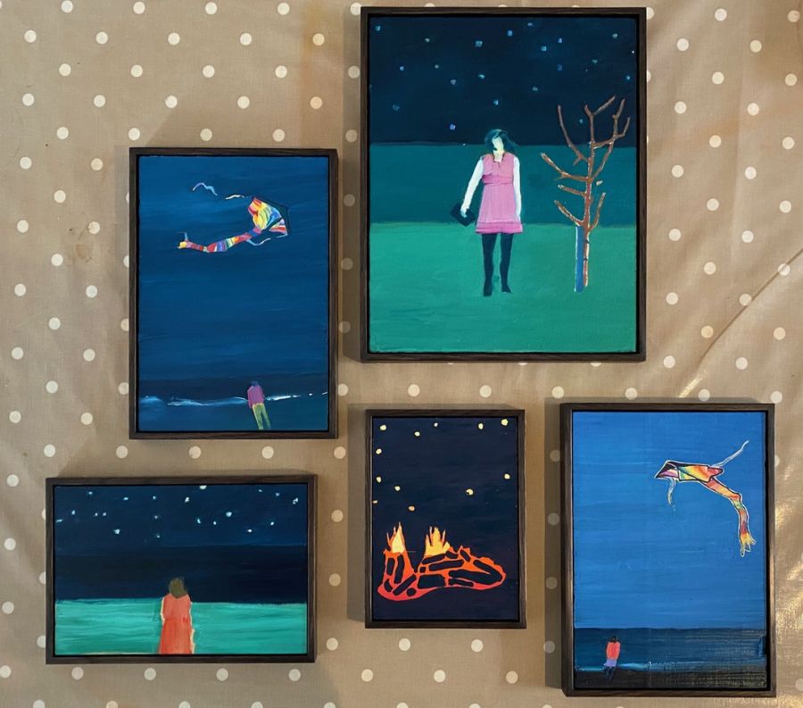 A cluster of framed pictures. From left: Man on the shore flying a kite, Woman standing next to a tree under the night sky, Woman looking out over the shore, Fire burning under the night sky, Figure on the shore flying a kite..