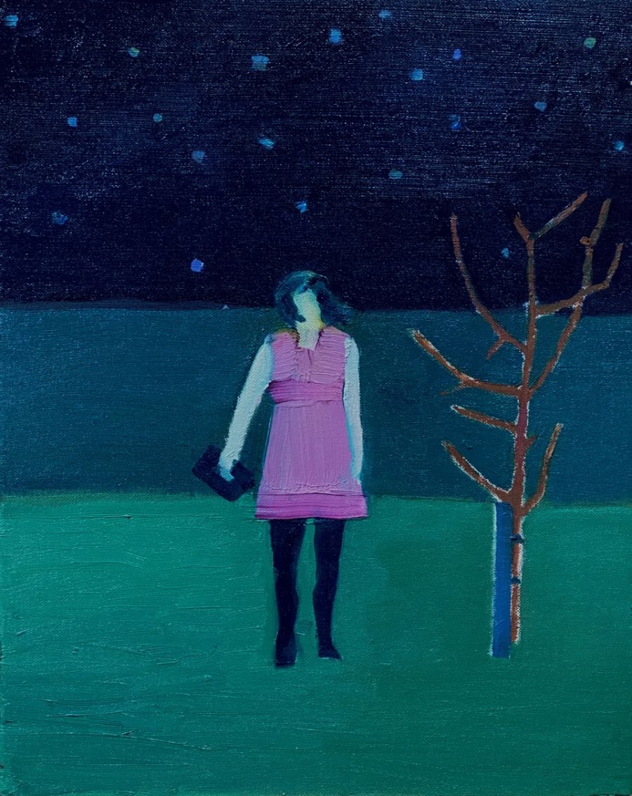 Woman standing next to a tree under the night sky..