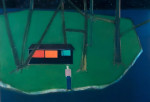 A figure standing on the edge of a shore outside a lit-up house on an island