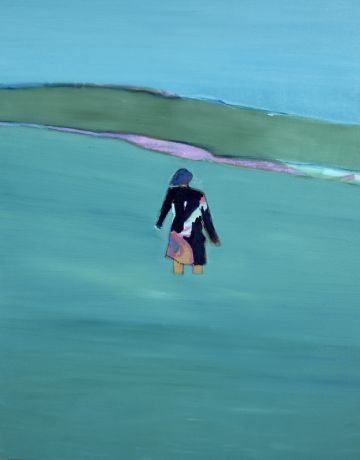 A figure standing in a blue sea looking towards land.